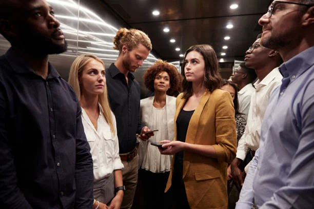 Work Colleagues Stand Waiting Together In An Elevator At Their Office